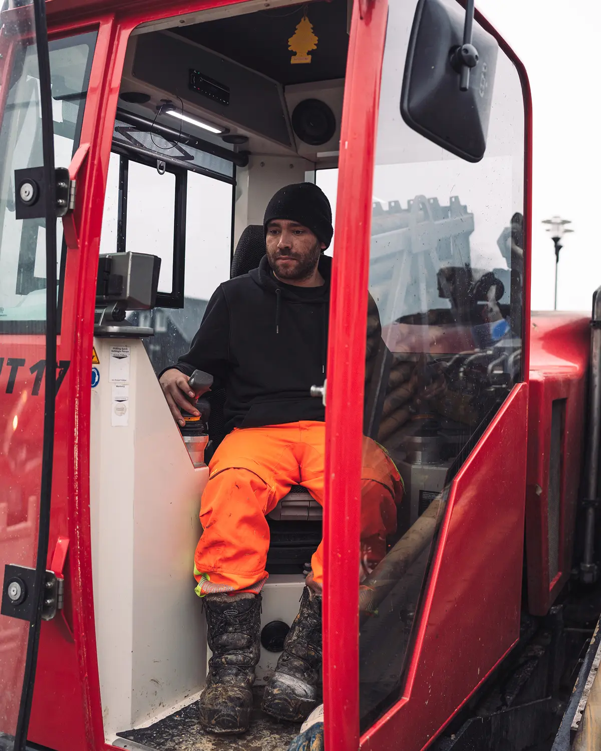 Maschinenführer sitzt in der Kabine eines roten Horizontalbohrgeräts